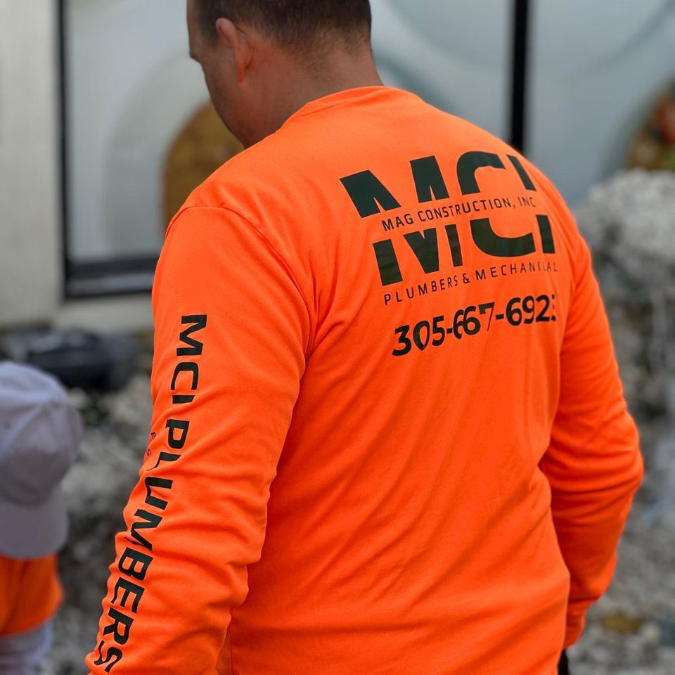 man in orange mci short on a work site